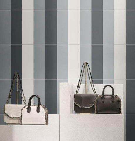 Linear grey subway tiles on a wall behind purse displays