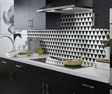 Trendy kitchen with monochromatic color scheme and triangle mosaic marble tile wall