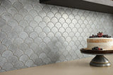 titanium grey patterned fan mosaic tile on kitchen backsplash with rustic cake on the counter in foreground