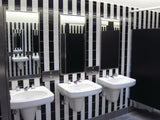 white and black gloss tile in stripes on bathroom wall showing vanity, subway tile
