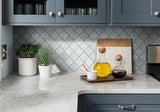 Polished gray lantern mosaic tile gleams in kitchen setting among oils and plants