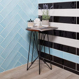 4x16 Gioia tile in various colors on a wall, one herringbone pattern and the other black and white striped.