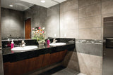 elite grey porcelain rectangle tiles with decorative inset in a commercial bathroom