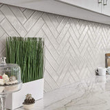 Greige handmade look wall tile set in a herringbone pattern on a modern kitchen backsplash