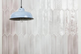 Sfumature crayon ehex picket wall tile in Fango installed on a wall behind a hanging lamp.