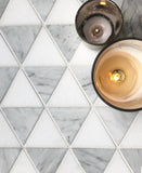 Triangle mosaic marble tile in natural tones with lit candles as accent